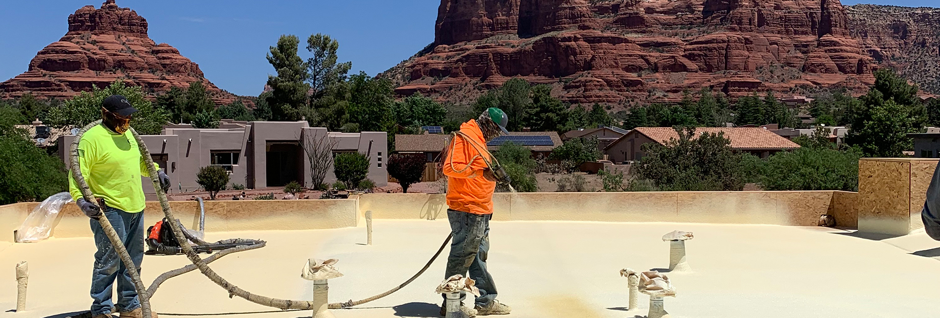 workers spraying a roof with foam